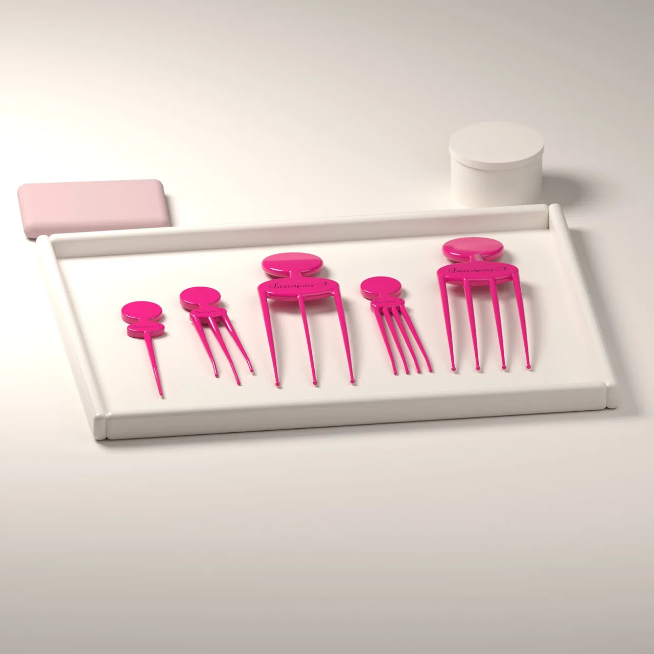All five pink scalp scratcher shapes resting on a tray